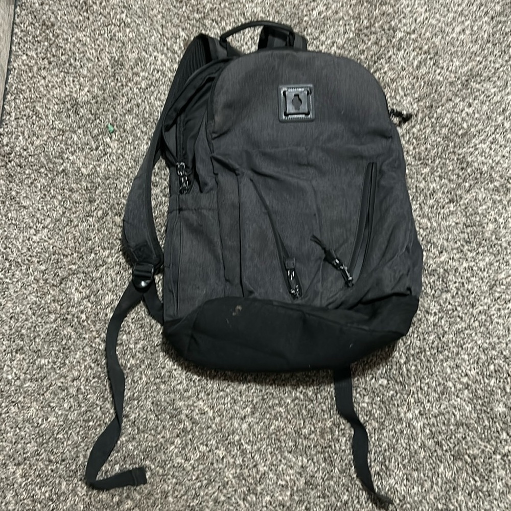 A grey eastsport bag that has a padded back, two water bottle holders.